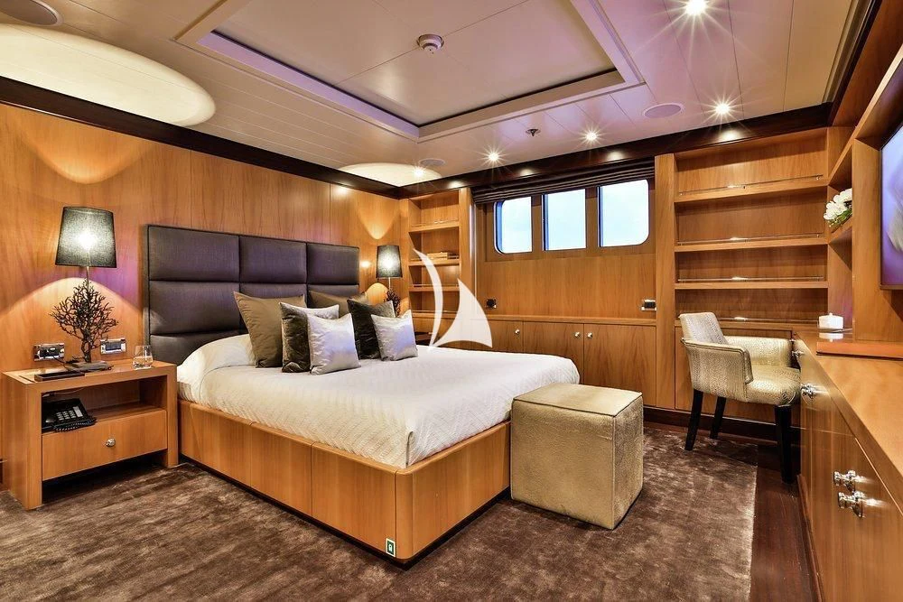 a bedroom with a bed and a chair aboard DENIKI Yacht for Sale