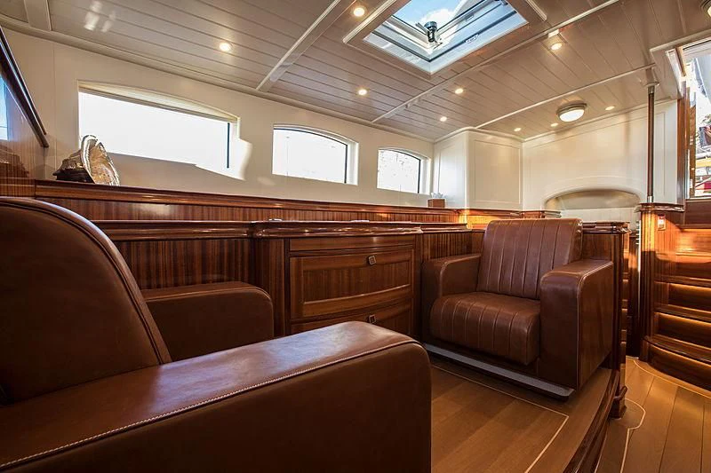 a room with leather couches and a wood table aboard VIJONARA Yacht for Sale