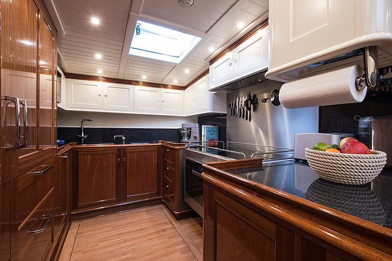 a kitchen with wooden cabinets aboard VIJONARA Yacht for Sale