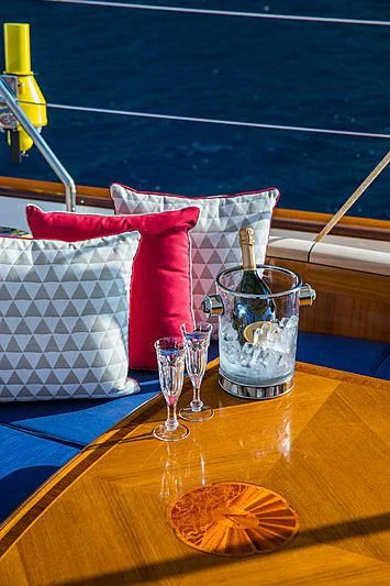a table with a glass and a couple of glasses on it aboard VIJONARA Yacht for Sale