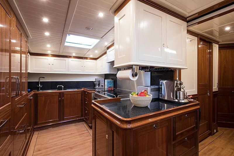 a kitchen with wooden cabinets aboard VIJONARA Yacht for Sale