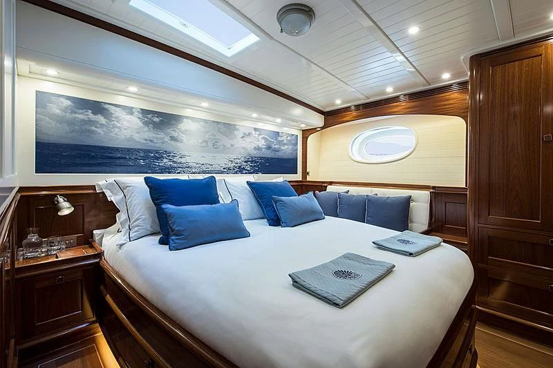 a bed with a white bed spread aboard VIJONARA Yacht for Sale