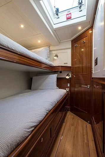 a bed with a wooden headboard aboard VIJONARA Yacht for Sale