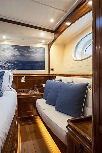 a bedroom with a bed and a painting on the wall aboard VIJONARA Yacht for Sale