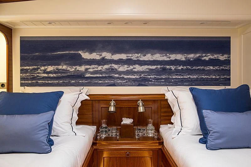 a room with a bed and a painting on the wall aboard VIJONARA Yacht for Sale