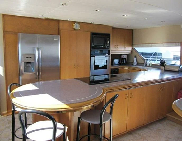 a kitchen with a table and chairs aboard LARA'S THEME Yacht for Sale