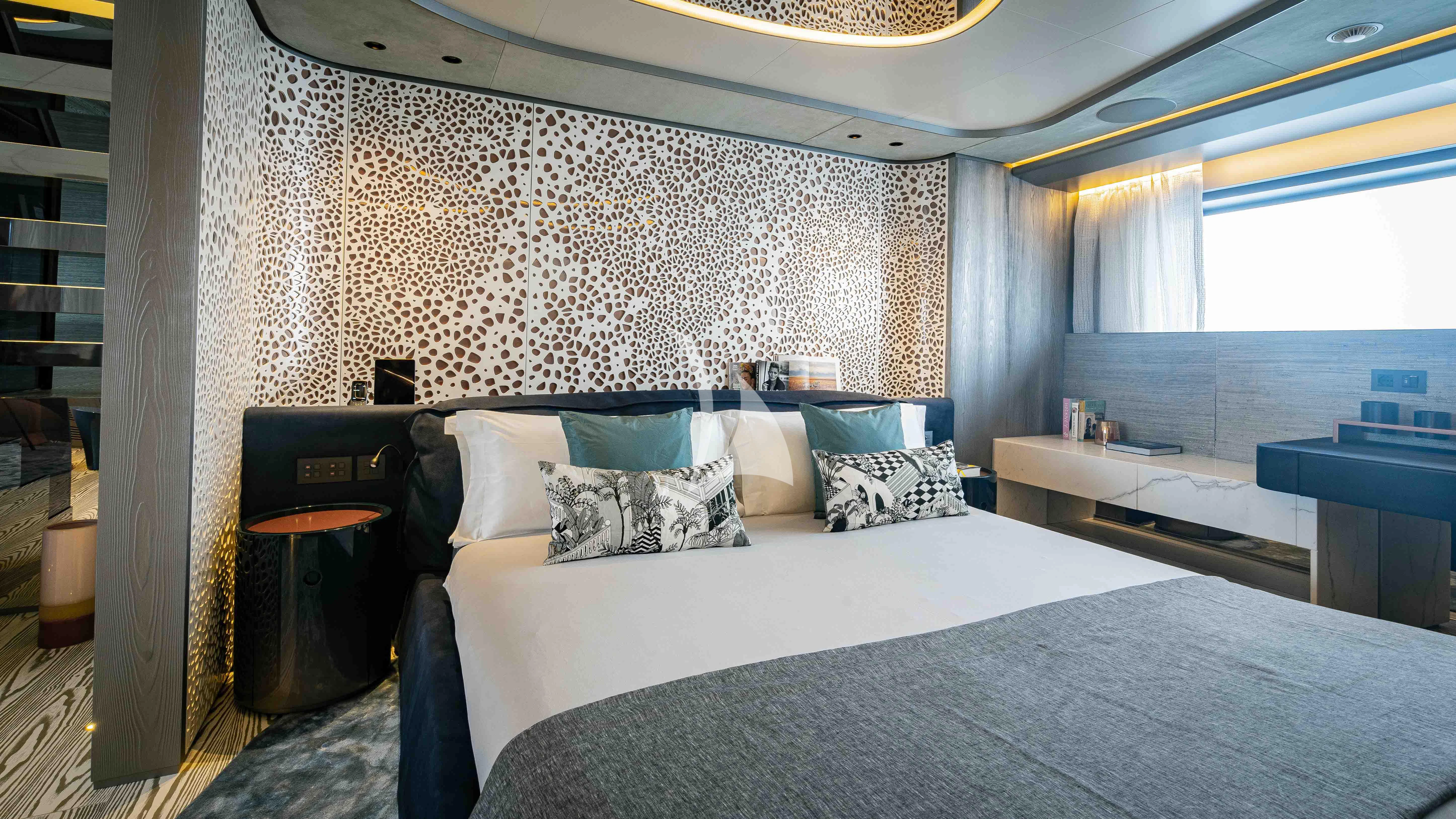 a bed with a blue and white bed spread aboard PANDION PEARL Yacht for Charter