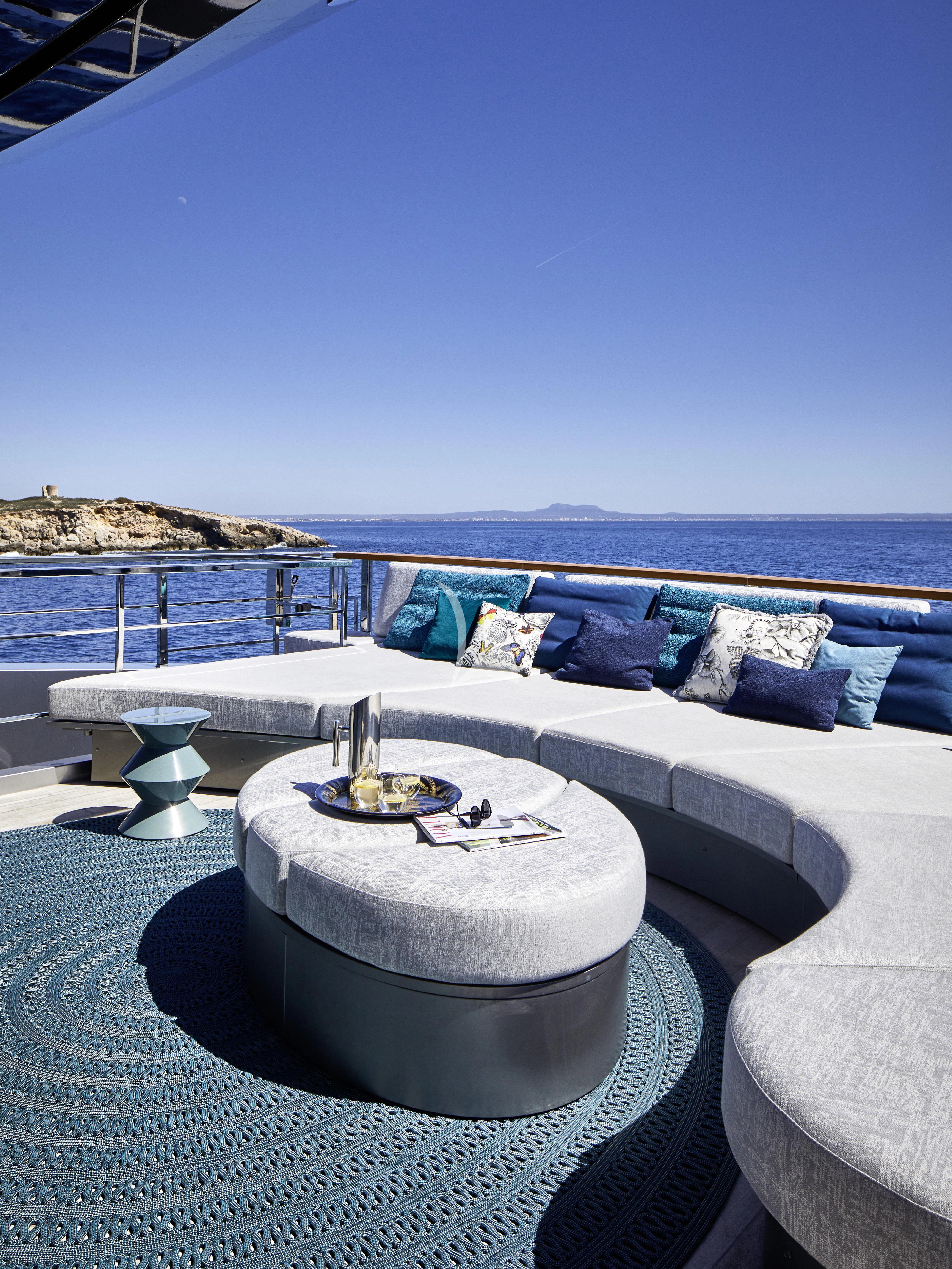 a pool with a couch and a table with a view of the ocean aboard PANDION PEARL Yacht for Charter