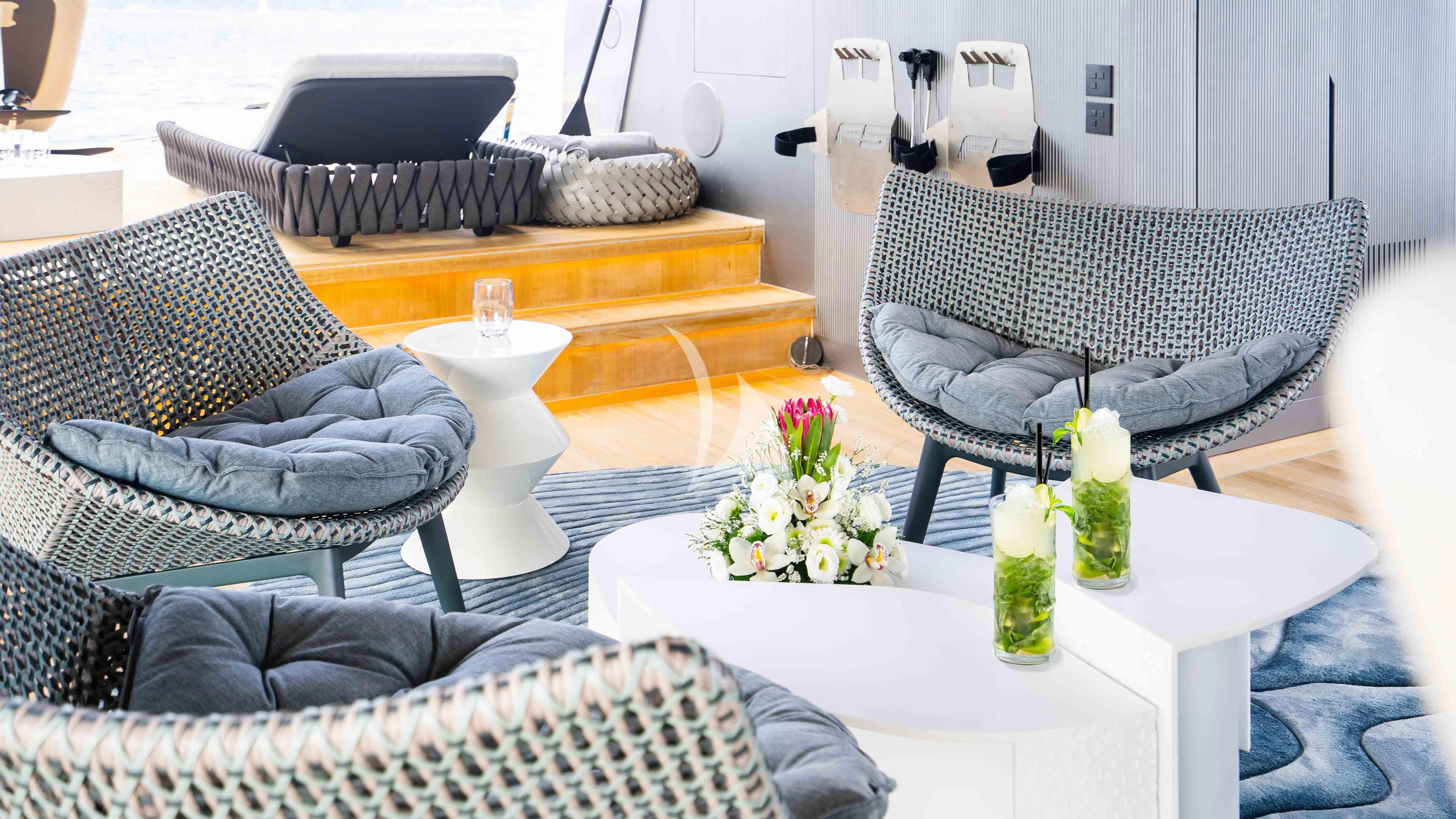 a living room with a couch and a table with a vase of flowers aboard PANDION PEARL Yacht for Charter