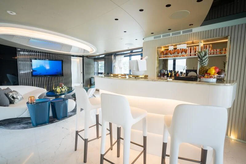 a room with a table chairs and a tv aboard PANDION PEARL Yacht for Charter