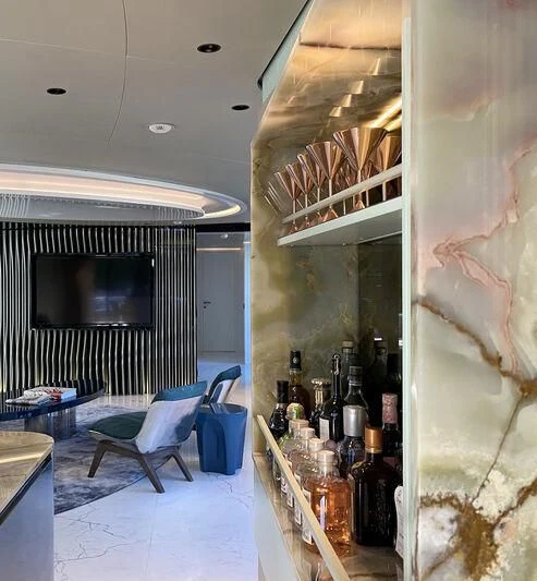 a room with a bar and a fireplace aboard PANDION PEARL Yacht for Charter