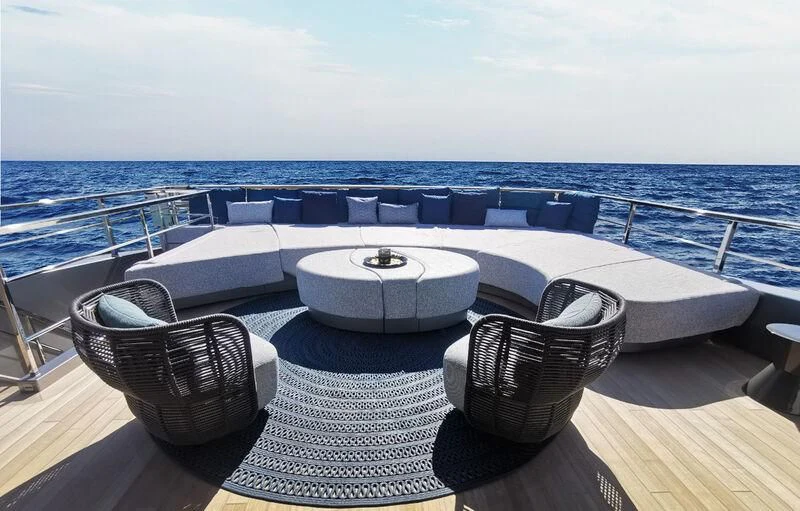 a large swimming pool with chairs on a deck overlooking the ocean aboard PANDION PEARL Yacht for Charter