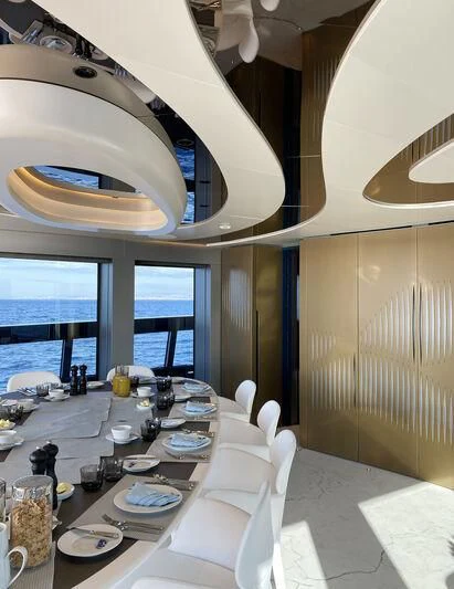 a large dining room with a large chandelier aboard PANDION PEARL Yacht for Charter