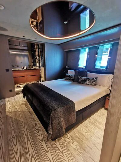 a bedroom with a large mirror above the bed aboard PANDION PEARL Yacht for Charter