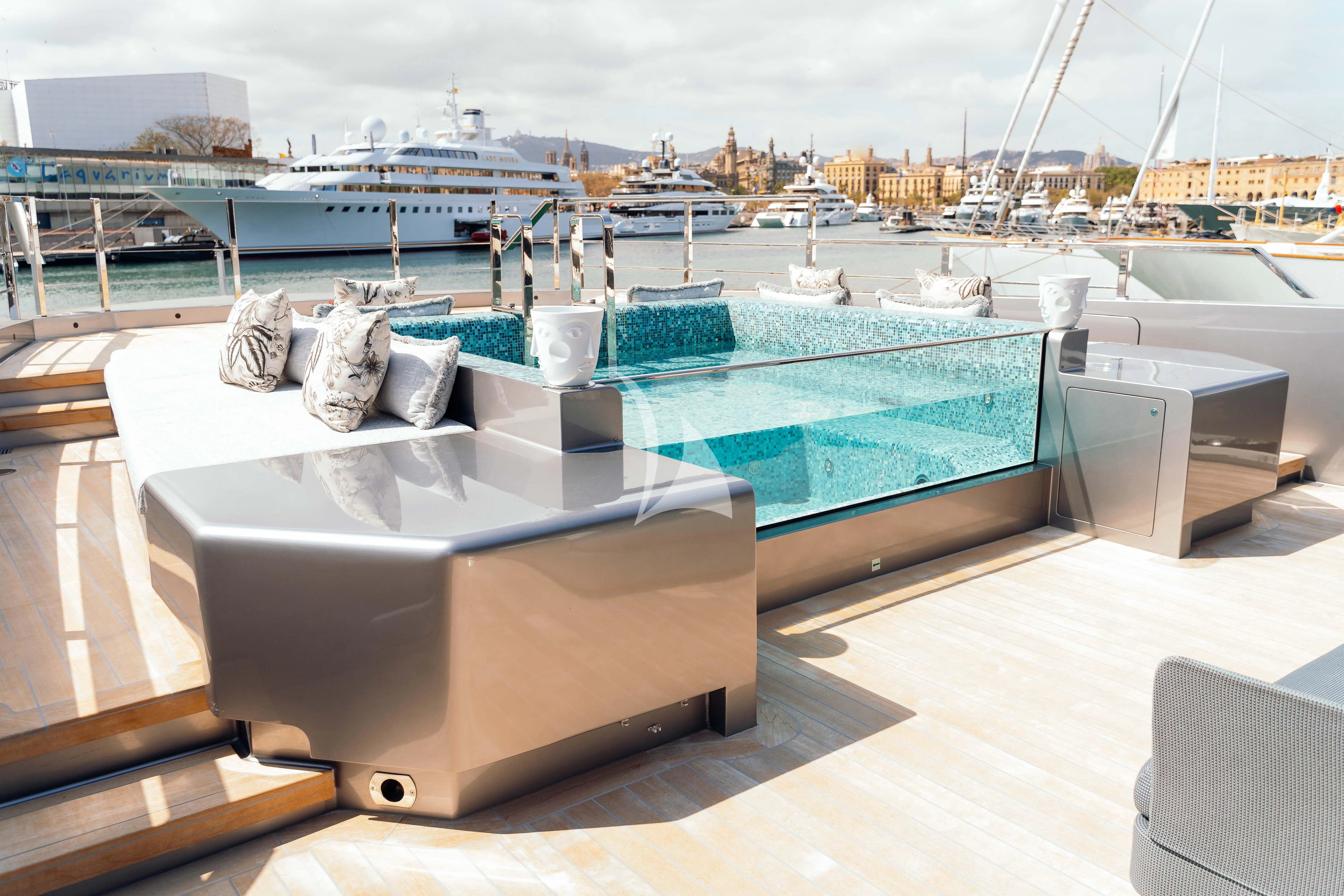 a pool with a table and chairs aboard PANDION PEARL Yacht for Charter