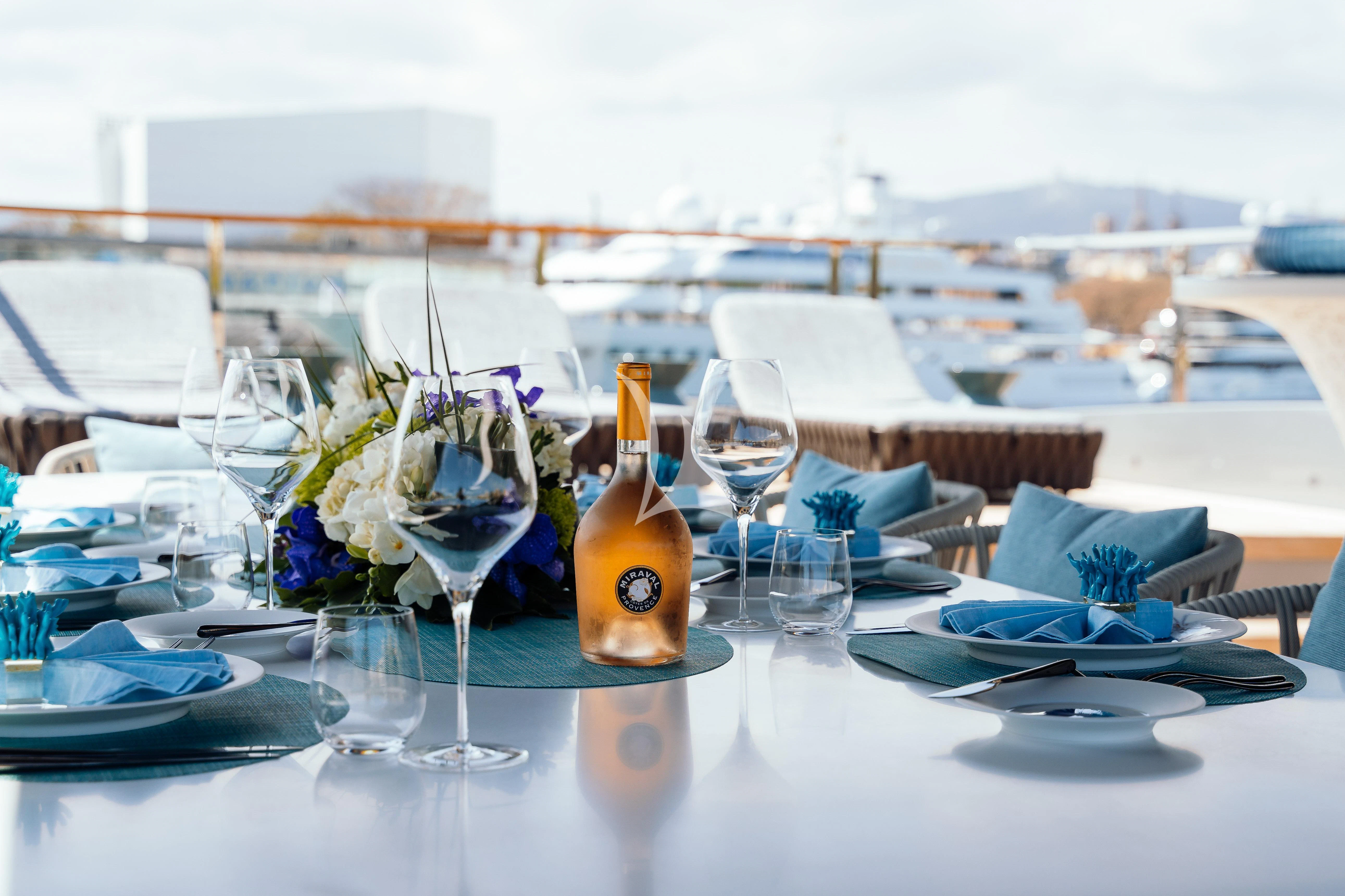 a table with a bottle and glasses aboard PANDION PEARL Yacht for Charter