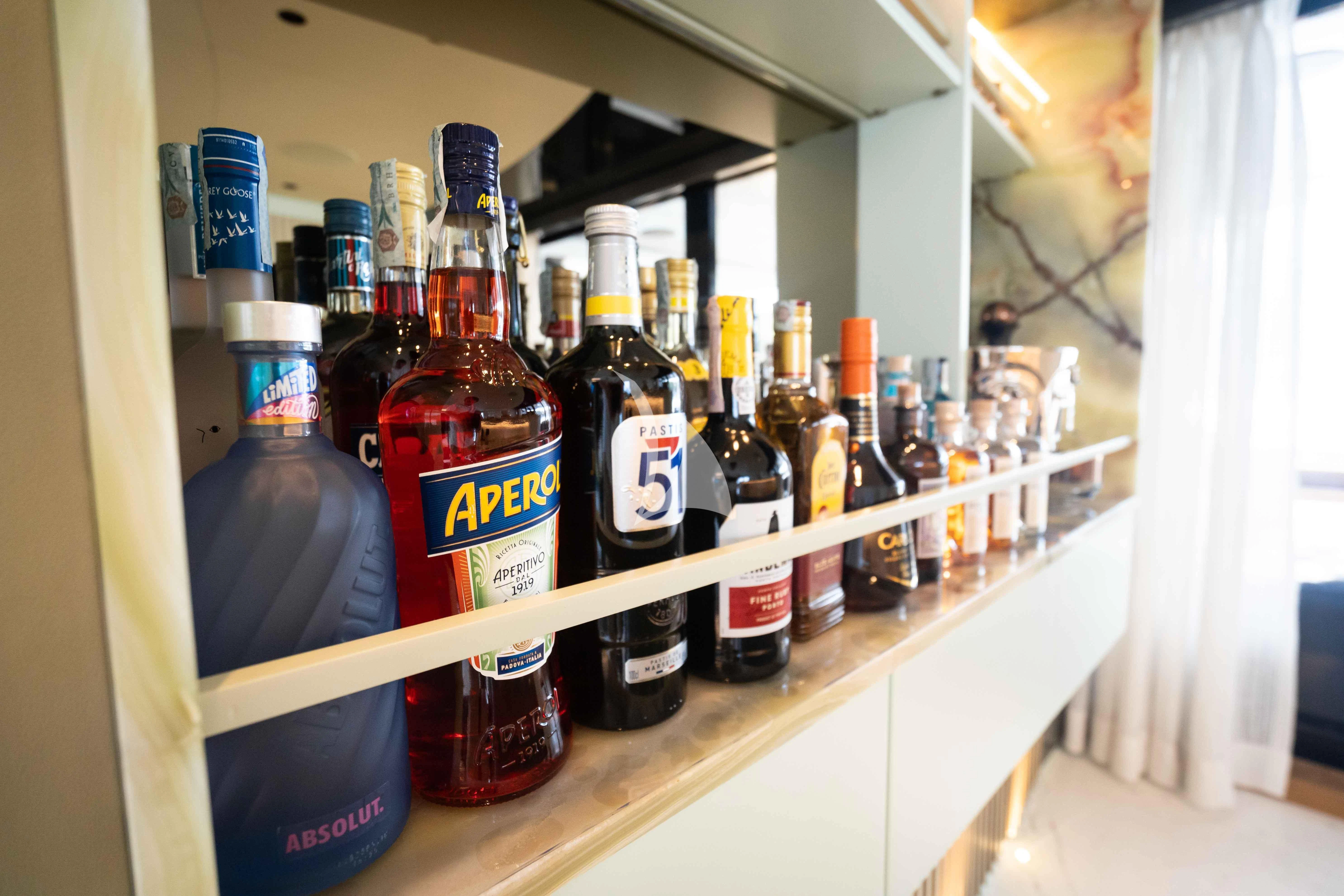 a shelf with bottles of alcohol aboard PANDION PEARL Yacht for Charter