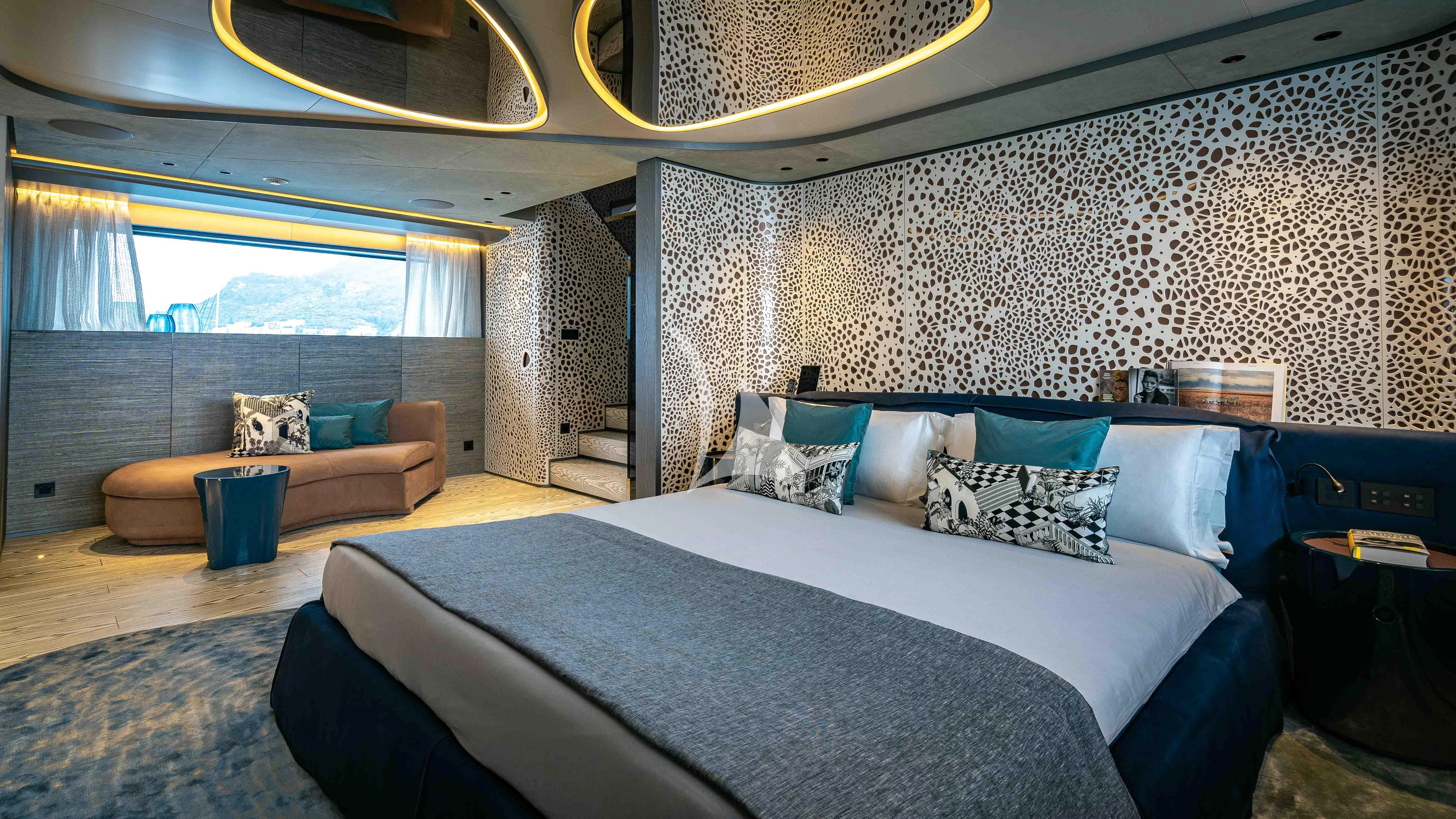 a bed with a blue comforter aboard PANDION PEARL Yacht for Charter