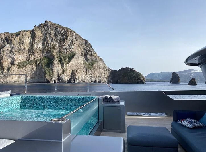 a pool with a large rock mountain in the background aboard PANDION PEARL Yacht for Charter