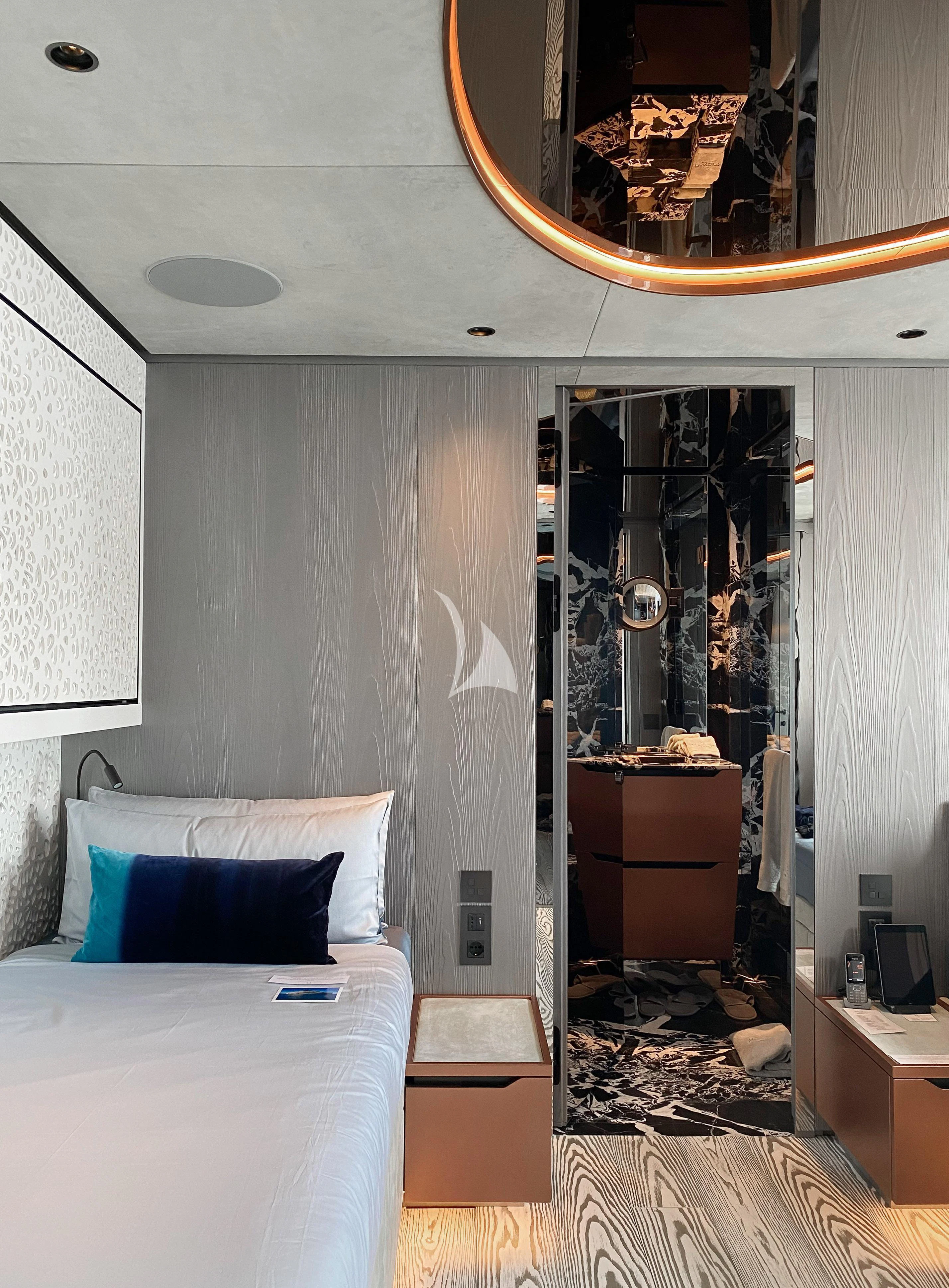 a bedroom with a bed and a mirror aboard PANDION PEARL Yacht for Charter