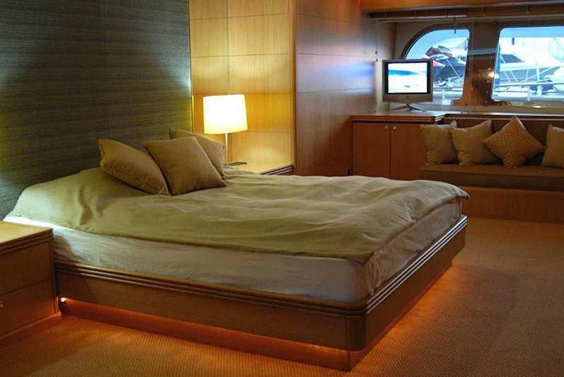 a bed with a television on the wall aboard GOODWILL Yacht for Sale
