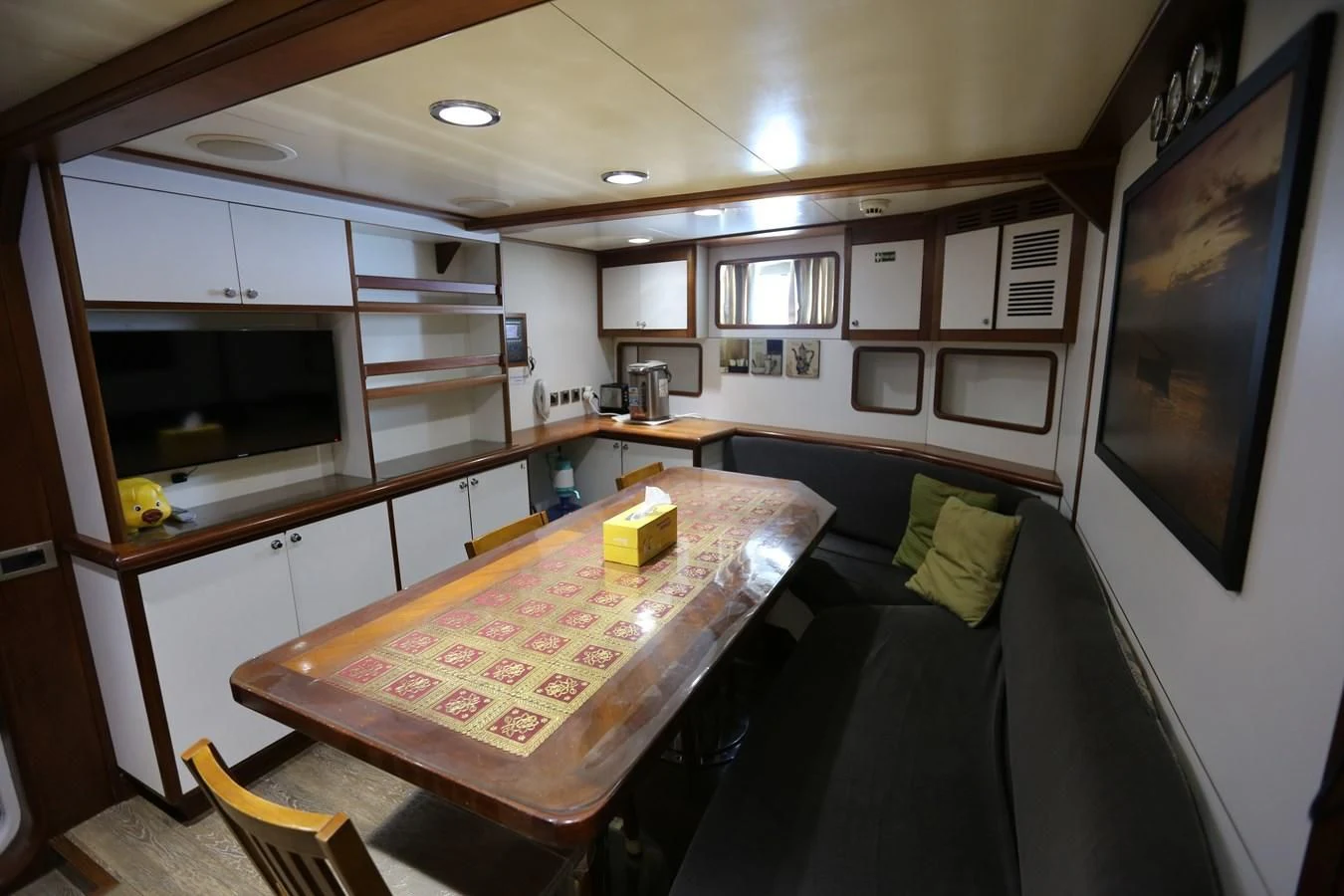 a kitchen with a table and a tv aboard GOODWILL Yacht for Sale