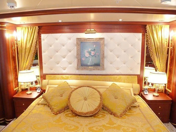 a bed with a painting on the wall aboard AQUAMARINA Yacht for Sale