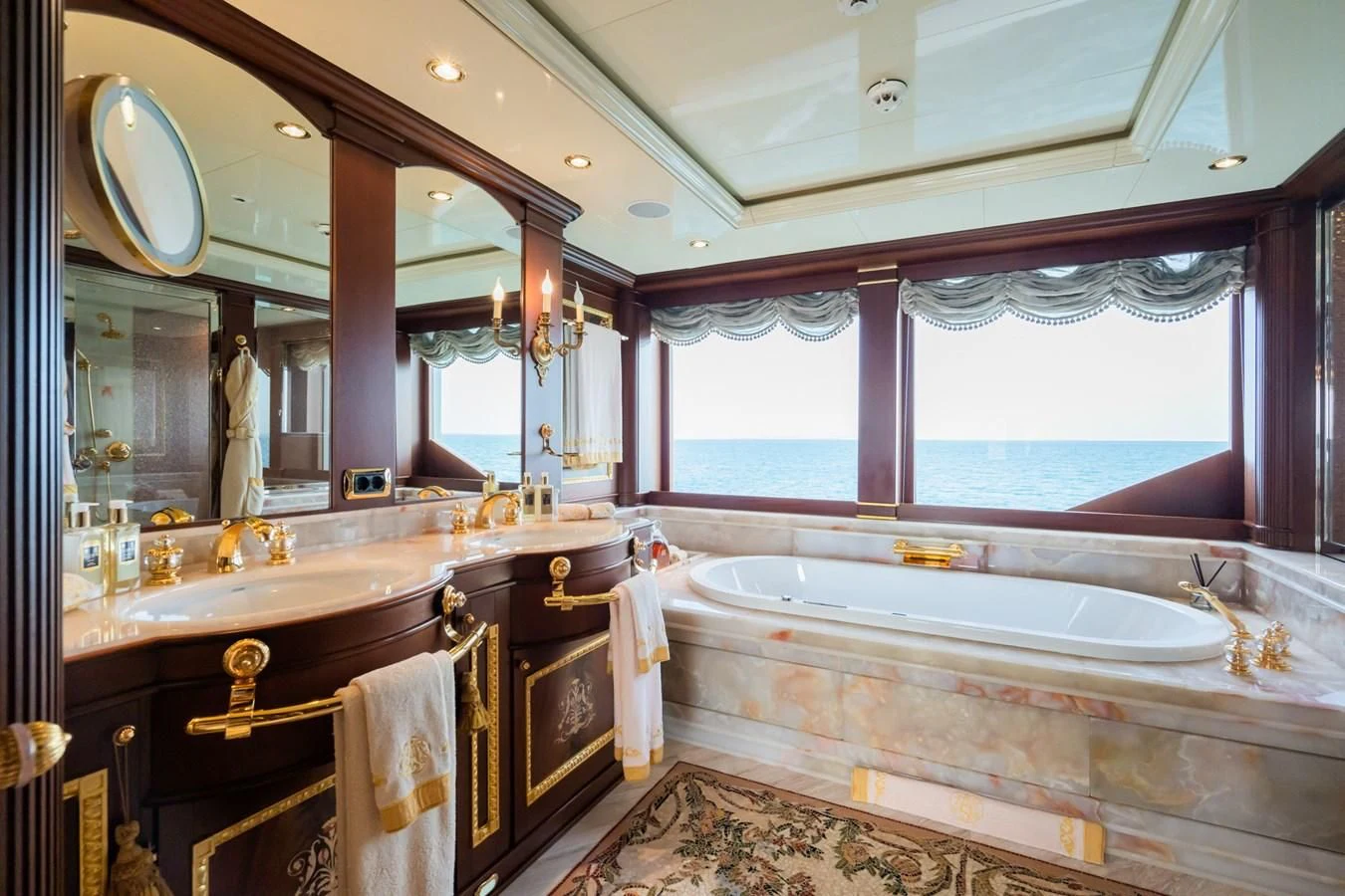a bathroom with a tub sink and a large mirror aboard AQUAMARINA Yacht for Sale