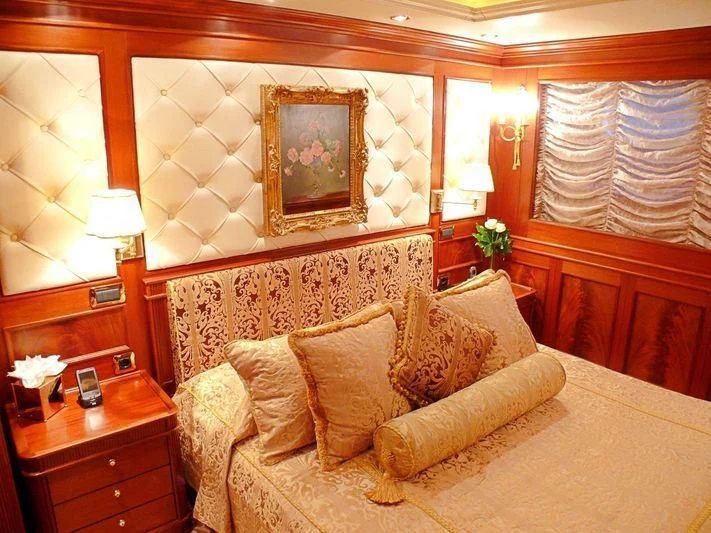 a large bed with a painting on the wall aboard AQUAMARINA Yacht for Sale