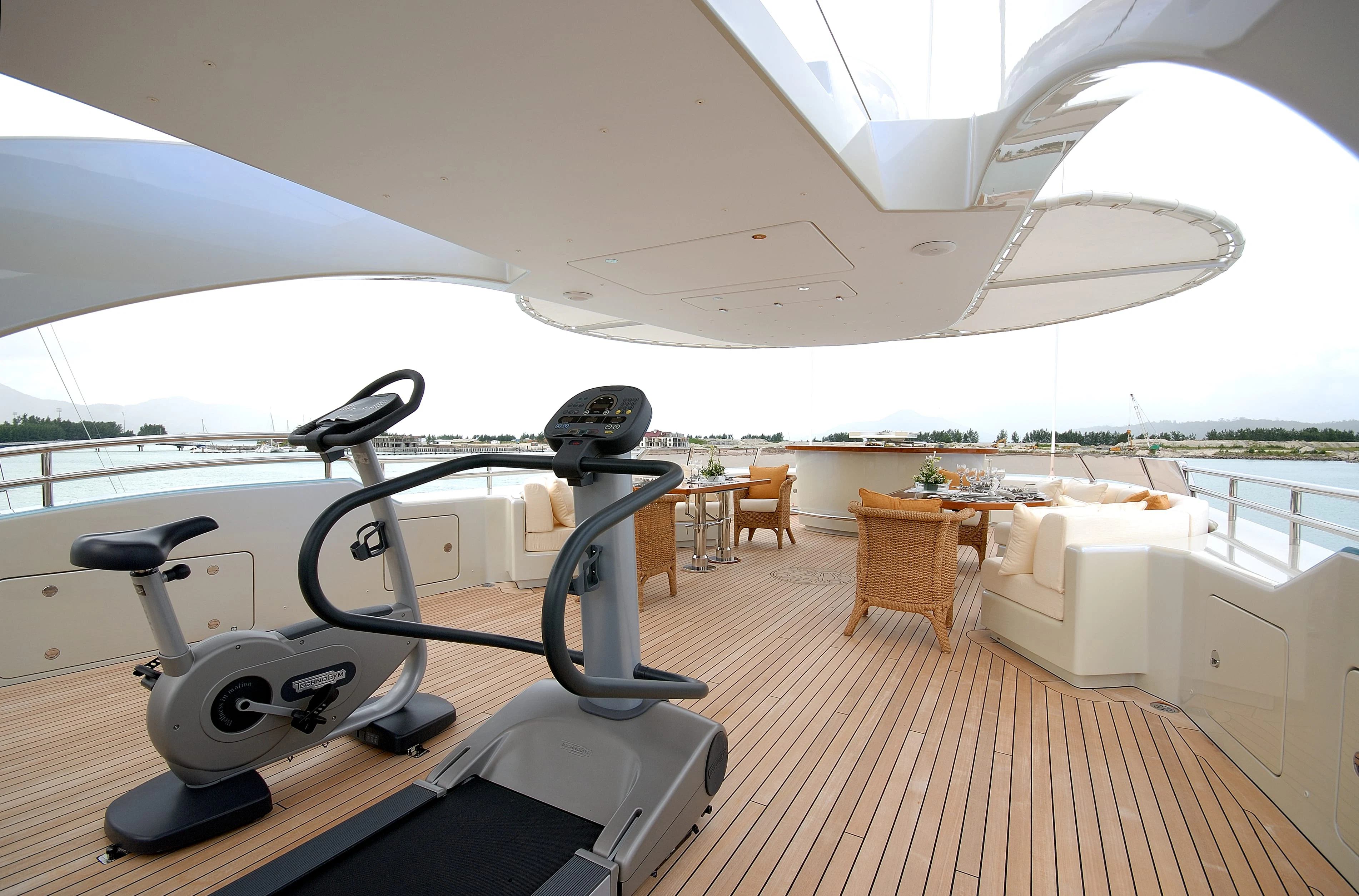 a large white lounge chair on a deck with a table and chairs aboard AQUAMARINA Yacht for Sale