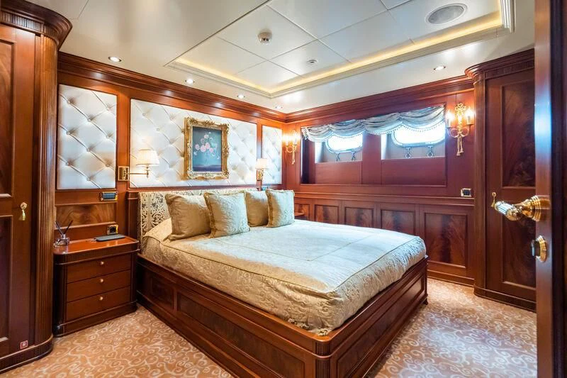 a bedroom with a bed and a wood cabinet aboard AQUAMARINA Yacht for Sale