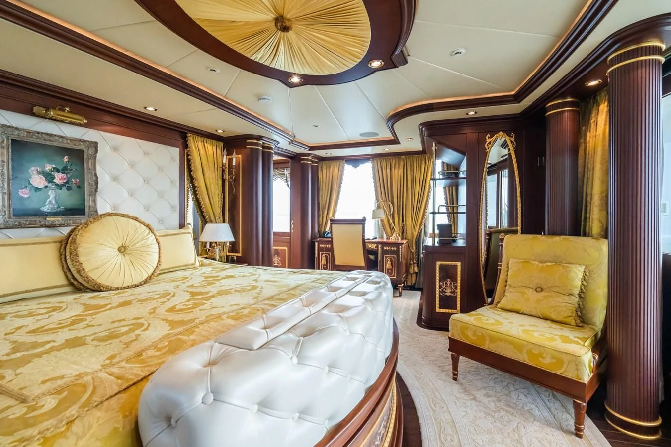 a bedroom with a large bed and a chandelier aboard AQUAMARINA Yacht for Sale