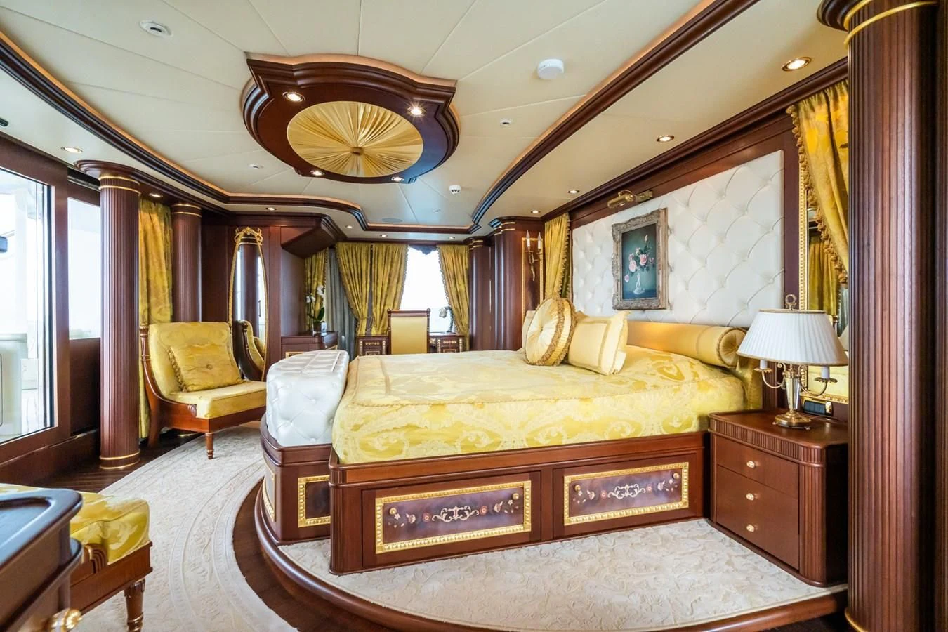 a bedroom with a bed and a chandelier aboard AQUAMARINA Yacht for Sale
