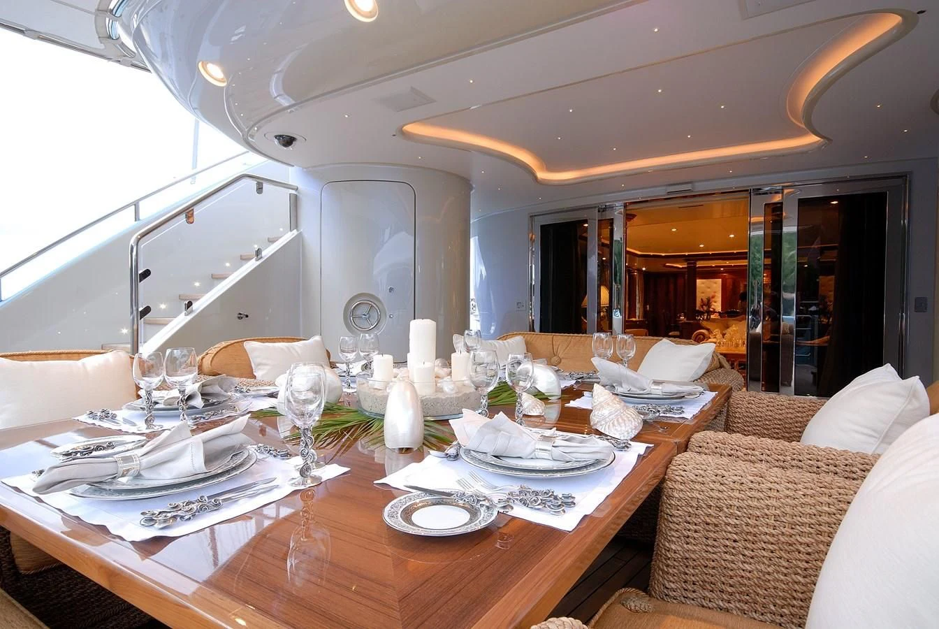 a dining table with plates and glasses aboard AQUAMARINA Yacht for Sale