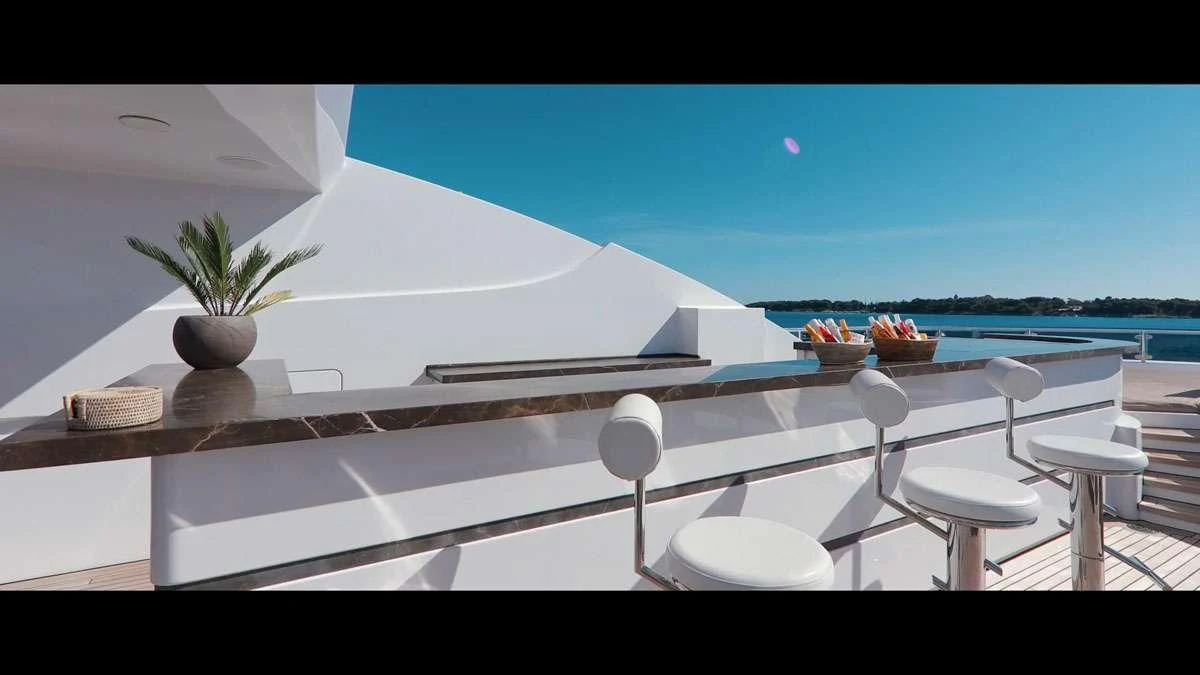 a large white room with a table and chairs and a plant on the table aboard PERSEFONI I Yacht for Sale