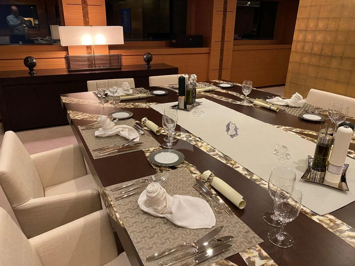 a table with a set of wine glasses and bottles on it aboard PERSEFONI I Yacht for Sale