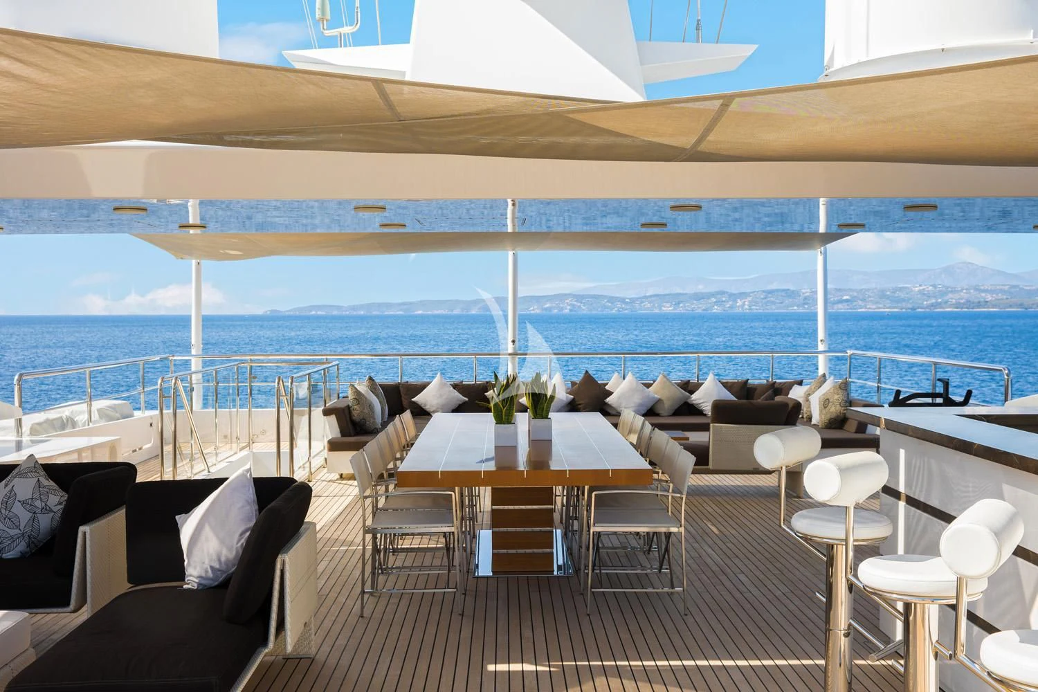 a room with a table and chairs on a deck overlooking the ocean aboard PERSEFONI I Yacht for Sale