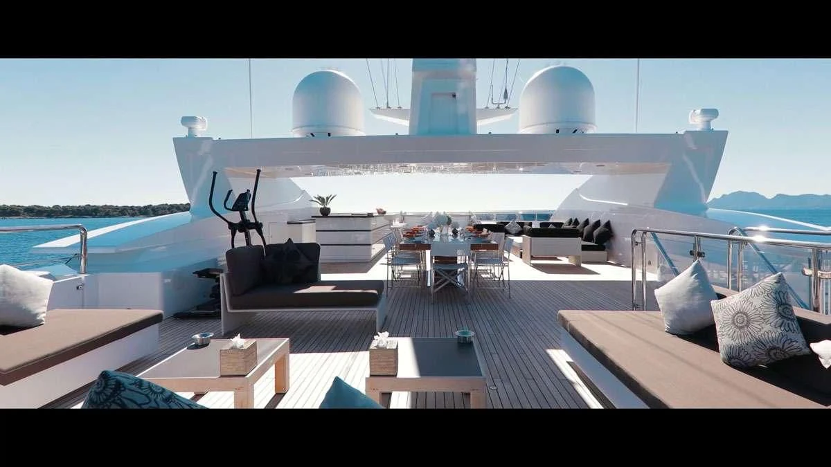 a large white building with a pool and lounge chairs aboard PERSEFONI I Yacht for Sale