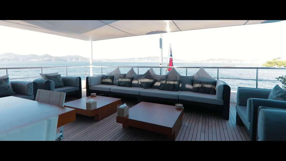 a living room with a large white couch and a large window aboard PERSEFONI I Yacht for Sale