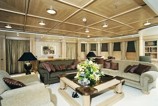 a living room with a table and couches aboard TUEQ Yacht for Sale