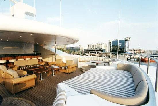 a deck with a large bed and a city in the background aboard TUEQ Yacht for Sale