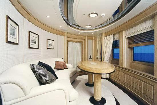 a room with a table and couch aboard TUEQ Yacht for Sale