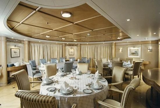 a large room with tables and chairs aboard TUEQ Yacht for Sale