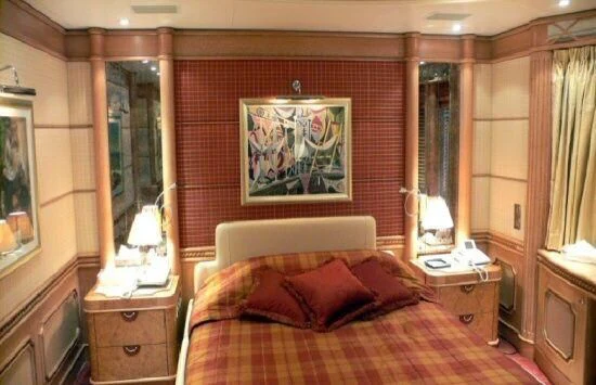 a bed with a painting on the wall aboard TUEQ Yacht for Sale