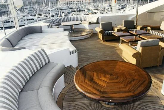 a room with a large group of couches and a table aboard TUEQ Yacht for Sale