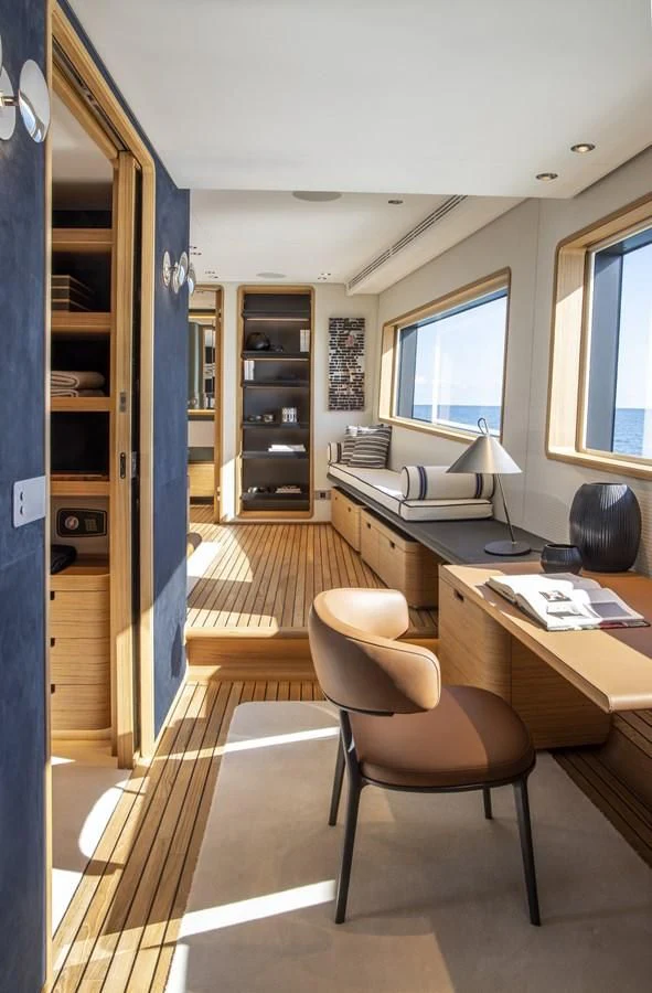 a room with a desk and a bed aboard UPSTREAM Yacht for Sale