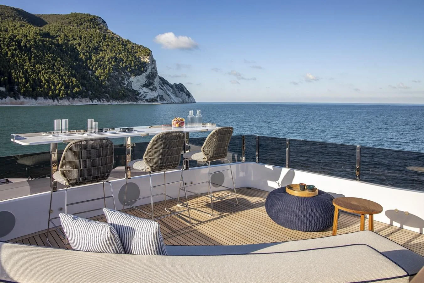 a deck with chairs and a table on it by the water aboard UPSTREAM Yacht for Sale