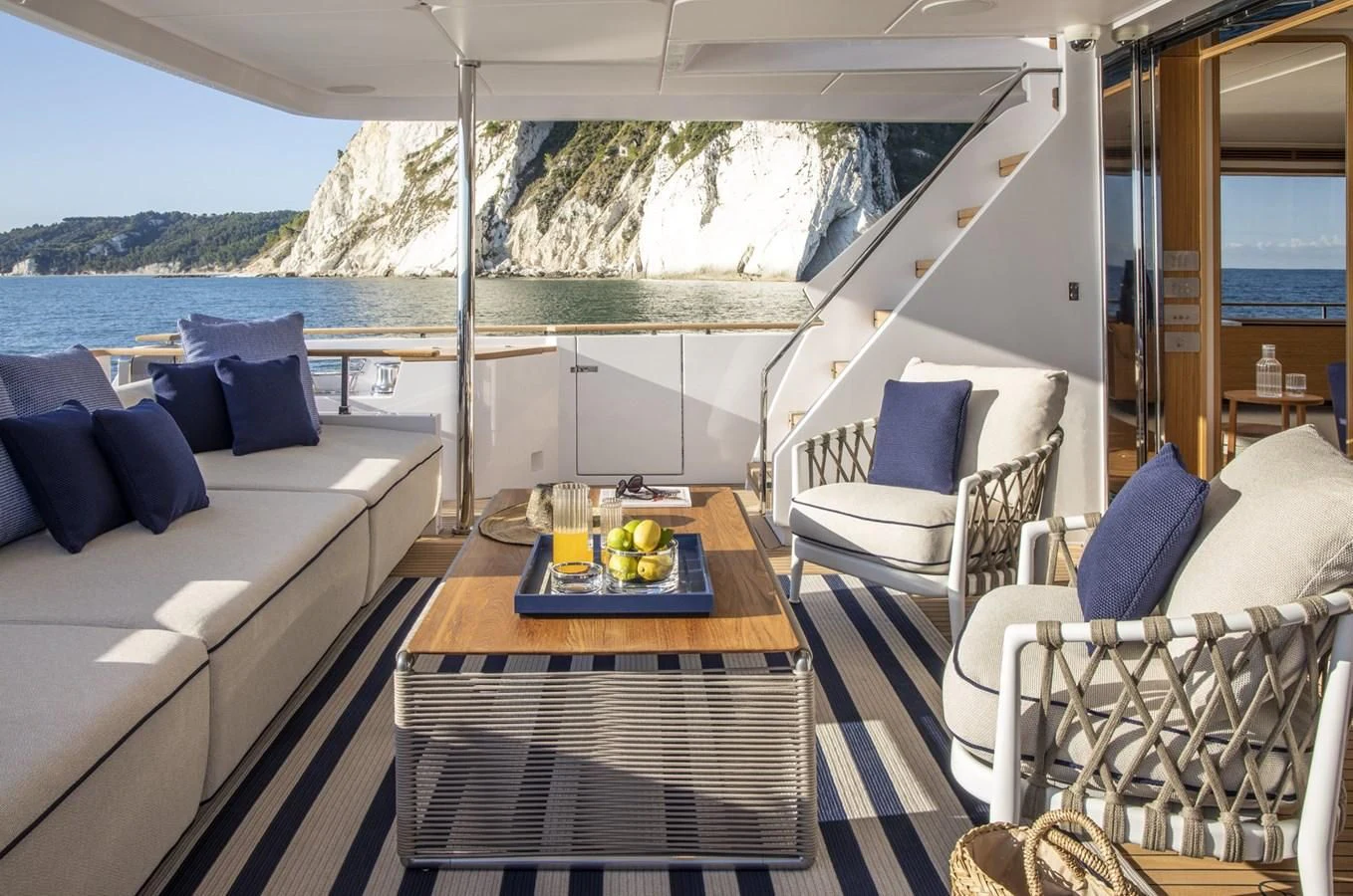 a table with chairs and a couch on a boat aboard UPSTREAM Yacht for Sale
