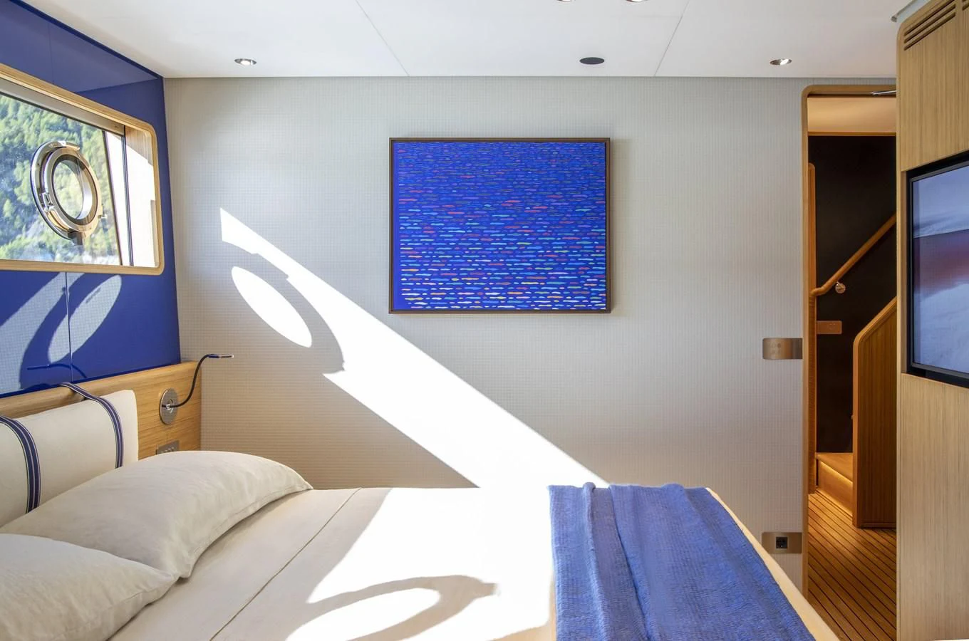 a bed with a blue blanket aboard UPSTREAM Yacht for Sale