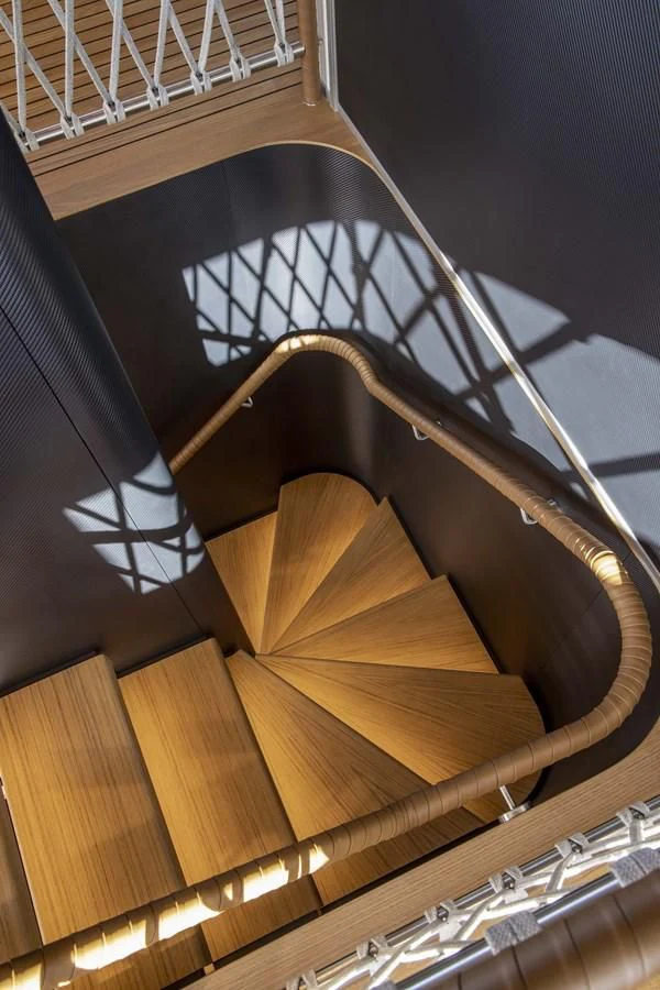a wooden staircase with a glass railing aboard UPSTREAM Yacht for Sale